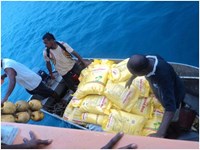 Unloading sacks of rice from the MV Southern Cross for transport to island communities.